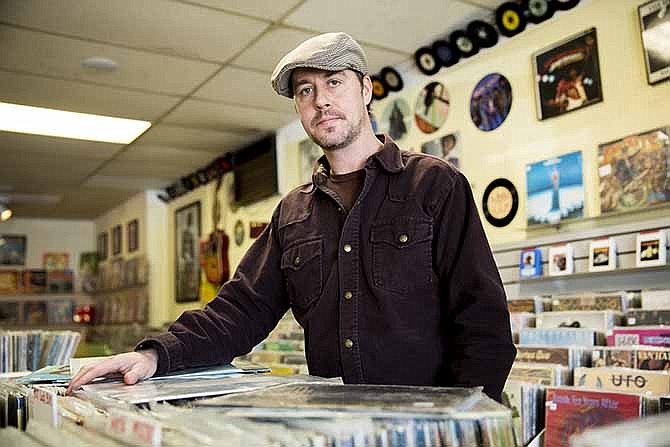 Jamie Rector, owner of In the Groove, puts away some loose records at his shop on Jefferson Street. In recent years Rector has noticed a spike in sales with the resurgence of vinyl records in music culture.