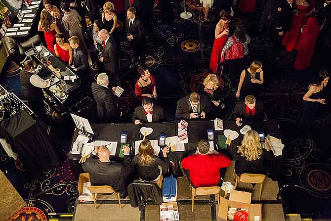 Attendants of the Mid-Missouri Heart Ball sign up for auction numbers and paddles Saturday evening at Capitol Plaza Hotel. The numbered paddles were used for the live auction, as well as the numbers being used as identifiers for the silent auction.