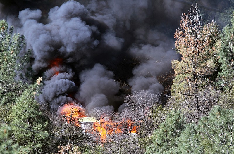 Smoke rises Sunday as officials burn a mobile home where more than 60 pounds of highly volatile explosive material was found in Redding, Calif. 