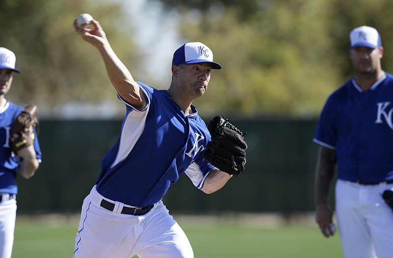 Jeremy Guthrie of the Royals throws to first as pitchers participate in pickoff drills during practice Saturday in Surprise, Ariz.