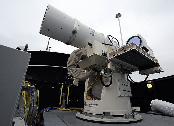 A laser weapon sits temporarily installed aboard the guided-missile destroyer USS Dewey in San Diego. The Navy plans to deploy its first laser on a ship this year, and intends to test an electromagnetic rail gun prototype aboard a vessel within the following two years.