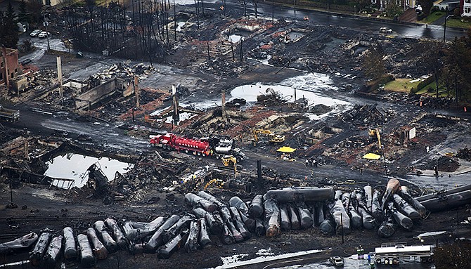 In this July 2013 photo, workers comb through debris after an oil train derailed and exploded in the town of Lac-Megantic, Quebec, killing 47 people. In response to Lac-Megantic, the National Transportation Safety Board and Transportation Safety Board of Canada called on regulators to require railroads to take stock of the risks along certain oil train routes and change them if needed.