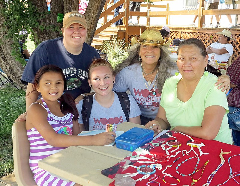 William Woods University students Rayel Lytle and Vanessa Davidson and Cyndi Koonse, coordinator of multicultural affairs, visit with a woman and child at Pine Ridge Reservation last summer.