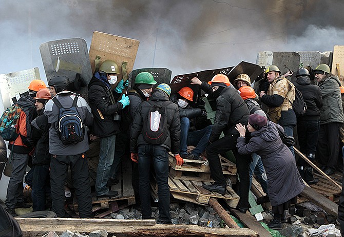 Anti-government protesters protected themselves with shields during clashes on Wednesday with riot police in Kiev's Independence Square, the epicenter of the country's current unrest.