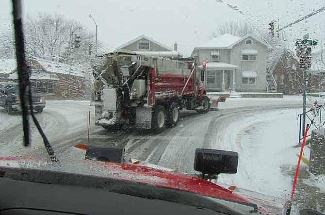 In this Feb. 5, 2014, file photo, Jefferson City snowplow driver Brandon Stegeman follows another plow as they work in teams to clear city streets.