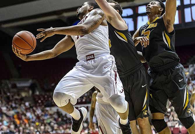 Alabama guard Trevor Releford (12) gets inside for a shot past Missouri forwards Ryan Rosburg and Jonathan Williams, III (3) NCAA college basketball game Saturday, Feb. 22, 2014, in Tuscaloosa, Ala.