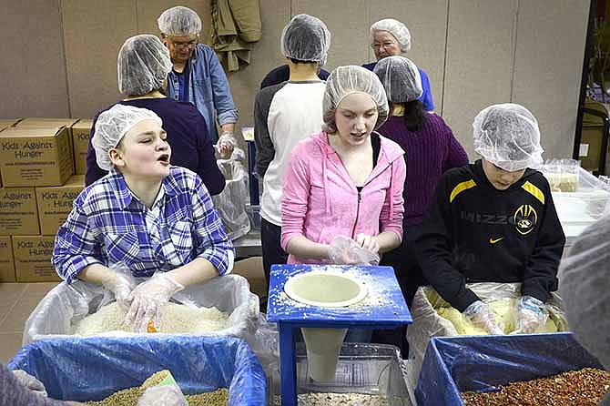 Abigail Witcher, 13, Billie McClain, 13, and Adam Crawford, 11, work together Saturday to fill bags of food for the Kids Against Hunger event at Memorial Baptist Church. The group prepared 10,000 meals, enough food to feed 16 people in Haiti for one year.