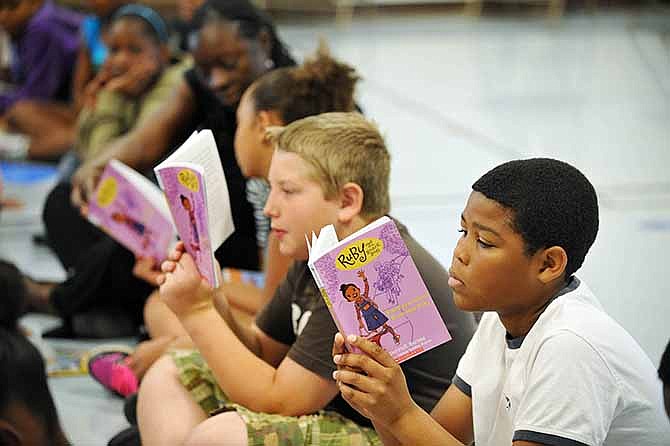 In this October 2011 file photo, Kahlil Foster, near, and Peyden Childress read along as a children's books author reads aloud to East Elementary students. More recently, the school earned the lowest score in the Jefferson City School District on its 2013 School Annual Performance Report.