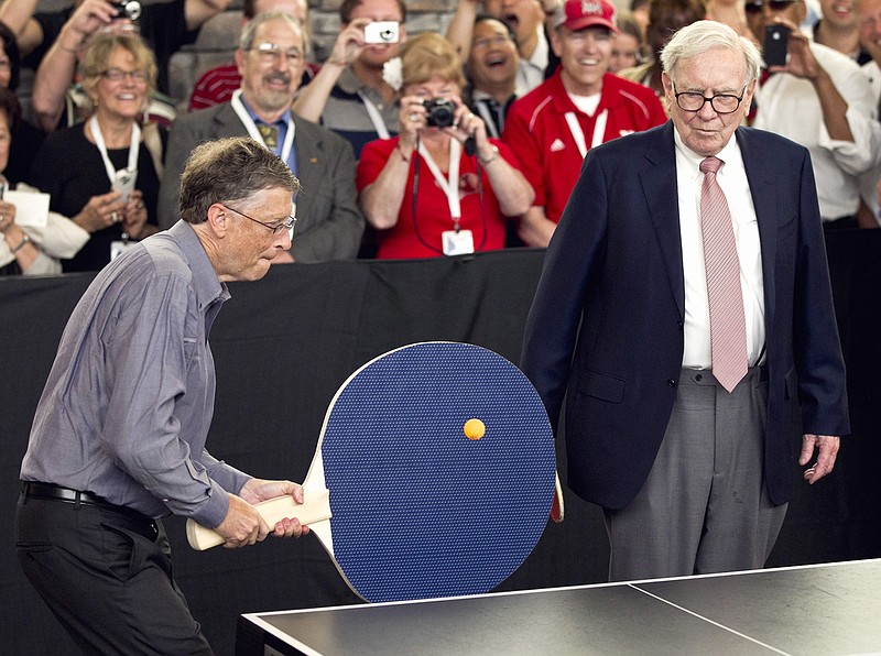 Warren Buffett, chairman and CEO of Berkshire Hathaway, right, watches Bill Gates use an oversize paddle as they play doubles against table tennis prodigy Ariel Hsing in Omaha, Neb. Members of the economic elite are looking for ways to reduce the nation's growing income inequality for a variety of reasons, from self-interest to pangs of conscience. 