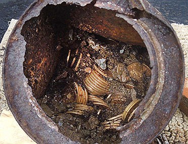 One of the six decaying metal canisters is shown filled with 1800s-era U.S. gold coins unearthed in California by two people who want to remain anonymous. The value of the "Saddle Ridge Hoard" treasure trove is estimated at $10 million or more.