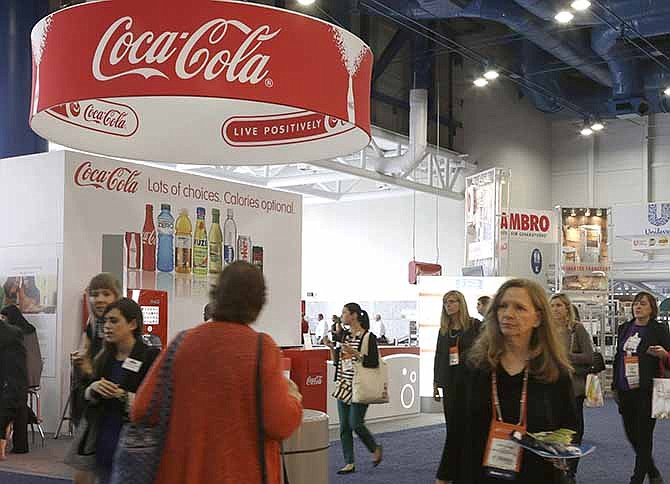 In this Oct. 21, 2013 photo, attendees at a conference for dietitians pass by a booth sponsored by Coca Cola, in Houston. As Americans struggle to improve their eating habits, big food companies are educating the professionals who help guide people on what's healthy and what's not. 