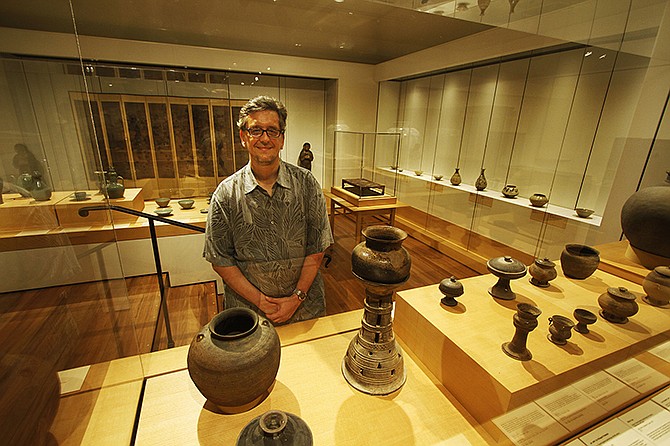 Shawn Eichmann, curator of Asian art for the Honolulu Museum of Art, poses in the Korean Gallery area at the museum in Honolulu. The museum discovered two paintings from late 16th-century Korea in its collection.