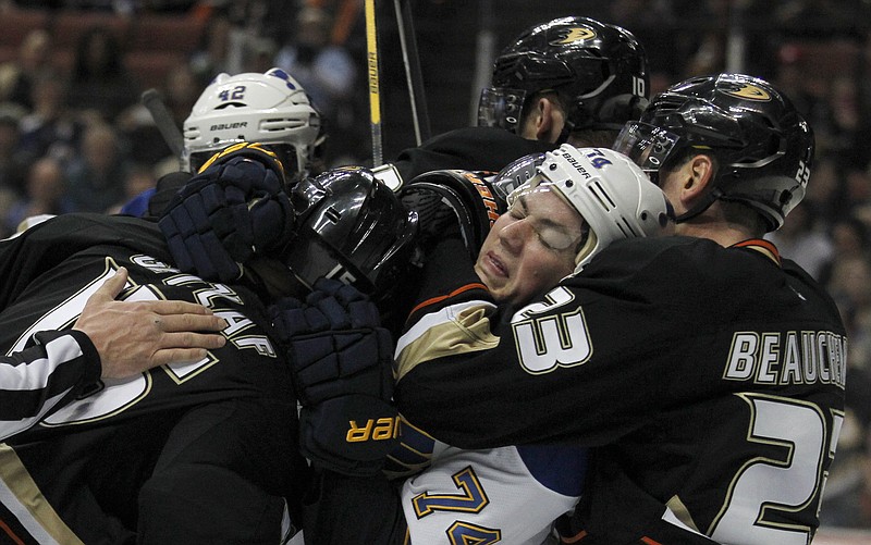 St. Louis Blues right wing T.J. Oshie (74) is pulled from a scrum by Anaheim Ducks defenseman Francois Beauchemin, right, while holding onto center Ryan Getzlaf, left, during the first period of an NHL hockey game on Friday, Feb. 28, 2014, in Anaheim, Calif. 