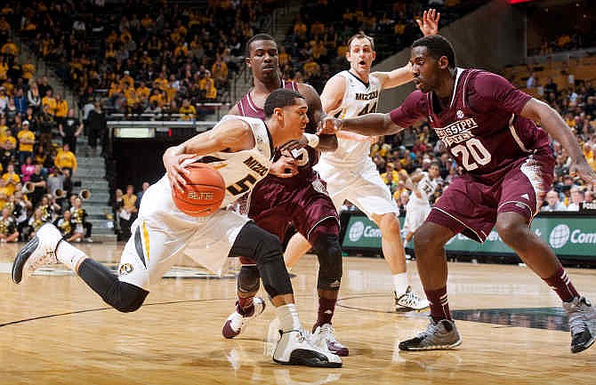 Missouri's Jordan Clarkson, left, tries to dribble past Mississippi State's Gavin Ware, right, and I.J. Ready as teammate Ryan Rosburg, back, calls for the ball during the first half of an NCAA college basketball game Saturday, March 1, 2014, in Columbia, Mo. 