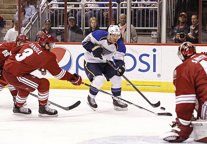 The Blues' Derek Roy skates the puck in on Coyotes goaltender Mike Smith as Keith Yandle (3) and Mikkel Boedker defend during the first period Sunday in Glendale, Ariz.