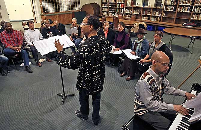 In this Feb. 27, 2014 photo, Daryl Walker, center, the director of The Spirituals Project Choir, oversees a rehearsal of his group, inside a church, in Denver. As The Spirituals Project enters its third decade, founder Arthur Jones is trying to spread the power he believes the music holds to build community across lines of race and class, and to move individuals to address personal and political challenges.