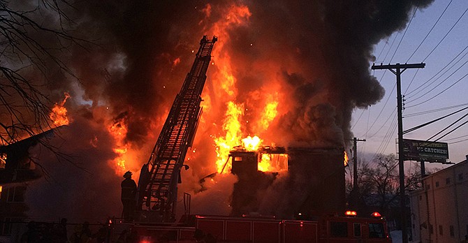 Firefighters battle a four-alarm fire at a three-story apartment complex Wednesday morning on Detroit's west side. An official says the fire forced some people to jump to escape. 
