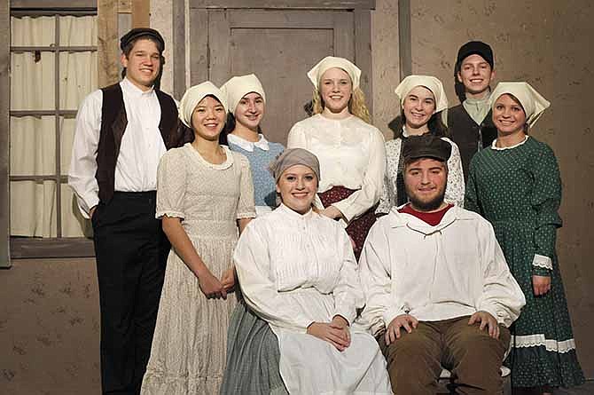 The Helias High School cast of Fiddler on the Roof pose for a portrait in front of the theater set. Maggie Jones (front, left) plays Golde and Trent Ludwig plays Tevye. Their daughters are played by, Elizabeth Troutwine (second row, left), Mary Conley, Suzie Kuensting, Laura Miserez and Samantha Sherman. Colton Ferguson (back, left) plays Perchik and David Huber plays Motel.