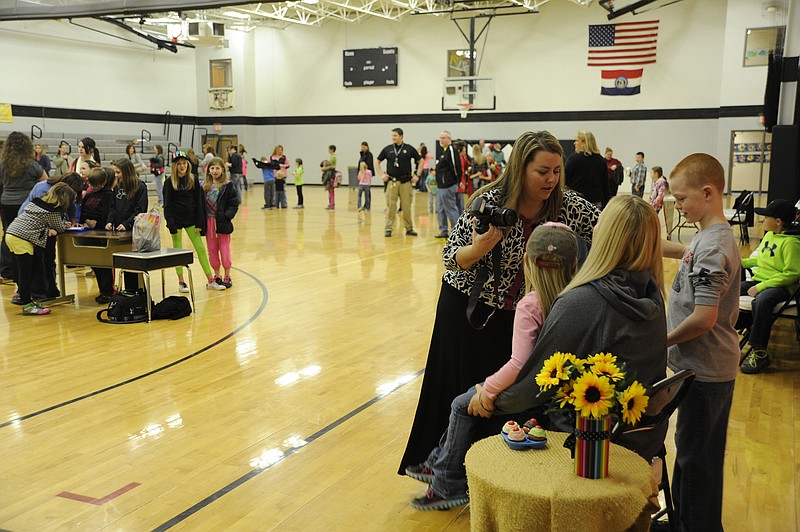 A line of parents and children at Friday's Muffins with Mom event, sponsored by the Cole County R-5 Elementary School PTO, stretched around the gym waiting for the free keepsake portrait by volunteer photographer Stacey Blomberg.