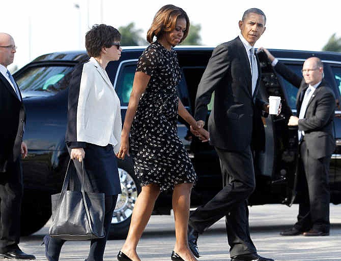 President Barack Obama walks with first lady Michelle Obama, center, and White House Senior Adviser Valerie Jarrett, left, to Marine One helicopter, after speaking at Coral Reef high school in Miami, Friday, March 7, 2014. The Obamas headed to Ocean Reef Club in Key Largo, Fla., to begin their weekend vacation. White House spokesman Josh Earnest defended Obama's trip to Key Largo, despite the ongoing crisis in Ukraine, arguing Obama would be able to monitor events from Florida.