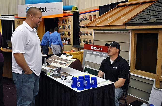 Russell Ireland discusses services with Ellerman Construction associate Bob Conaway at the company's EXPO 2014 booth Saturday at the Lake of the Ozarks.
