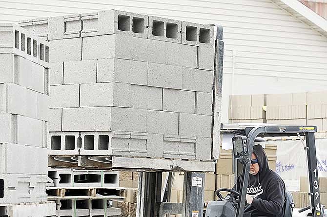 Ron Roy uses a heavy duty forklift to load pallets of eight-inch concrete blocks onto a delivery truck in Jefferson City. Blocks similar to these were made using finely ground recycled rubber tires as an aggregate. It was part of a research project through the Missouri University of Science and Technology at Rolla.