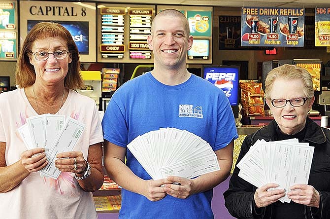 Sharon Bargielsk, left, Ryan Claspill and Beverly Severance, at right, hold up their tickets awarded them for third, second and first place, respectively, in the recent News Tribune/Capital 8 Theaters Oscar Contest. The three were at Capital 8 Friday to retrieve their winnings.