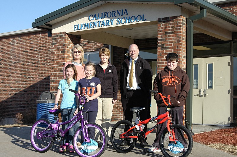 Front row, from left, are: girls bicycle winners Haley Duncan and Cadence Winkler; and boys bicycle winner Ryan Bleich and back row, Bonnie George of Commerce Bank, Sarah Holtsclaw of Central Bank and Scott Williams, California McDonald's manager. The bikes donated by Commerce Bank and Central Bank were given away in a drawing held at McTeacher's Night. 

