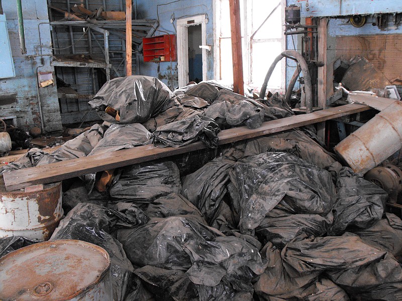 This photo taken on March 3, 2014, and provided by the North Dakota Health Department, shows bags full of radioactive oil filter socks, the nets that strain liquids during the oil production process, piled in an abandoned building in Noonan, North Dakota. 