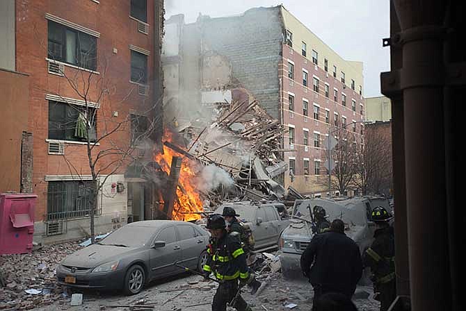 Firefighters work the scene of an explosion that leveled two apartment buildings in the East Harlem neighborhood of New York, Wednesday, March 12, 2014. Con Edison spokesman Bob McGee says a resident from a building adjacent to the two that collapsed reported that he smelled gas inside his apartment, but thought the odor could be coming from outside. 
