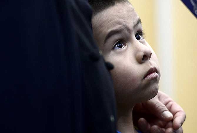 Allan Chavarria-Rodriguez, 4, snuggles next to his mother, Marta Rodriguez as she talks to reportes at the police station in Brighton, Colo., Wednesday, March 12, 2014. Police say Chavarria-Rodriguez was found unharmed after Ryan Stone abandoned an SUV he had allegedly stolen in Longmont, Colo. (AP Photo/The Daily Camera, Mark Leffingwell)