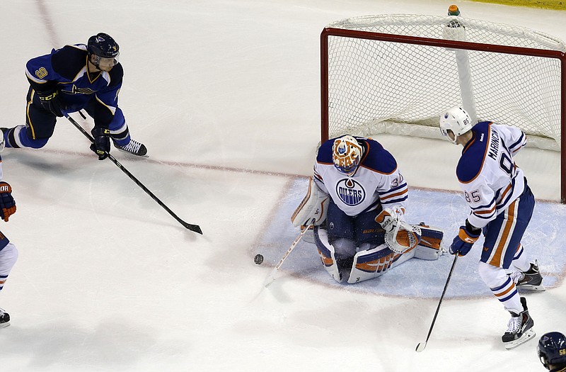 The Blues' Jaden Schwartz (left) prepares to score on a rebound off Oilers goalie Ben Scrivens as Edmonton's Martin Marincin looks on during the third period of Thursday's game in St. Louis.