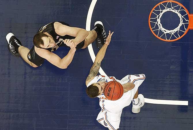 Florida guard Scottie Wilbekin (5) shoots over Missouri forward Ryan Rosburg (44) during the second half of an NCAA college basketball game in the quarterfinal round of the Southeastern Conference men's tournament, Friday, March 14, 2014, in Atlanta. 