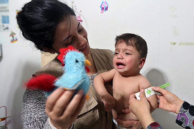 Aid workers measure the upper arm circumference to check for signs of malnutrition Tuesday in 1-year-old Syrian refugee Mahmoud al-Khatar at a medical clinic in the town of Kab Elias in Lebanon's Bekaa Valley. Three years after Syria's uprising began to overthrow President Bashar Assad, spiraling into a war that has killed over 140,000 people and sending over 2.5 million people fleeing into neighboring countries, aid workers say are now seeing malnutrition emerge, once a barely known scourge in Syrian society.