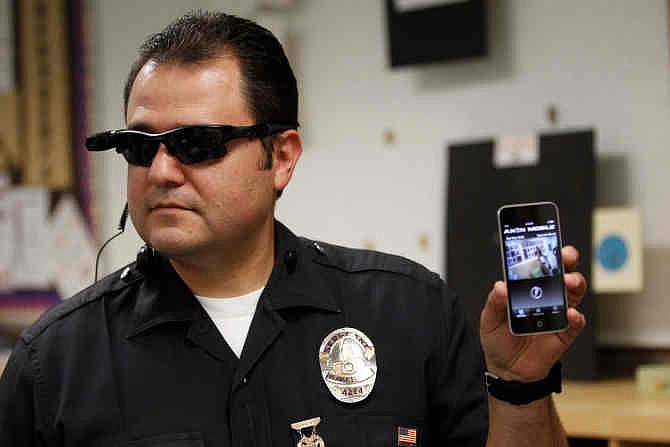 This Jan. 15, 2014 file photo shows Los Angeles Police Sgt. Daniel Gomez demonstrating a video feed from his camera into his cellphone as on-body cameras are demonstrated for the media in Los Angeles. Thousands of police agencies have equipped officers with cameras to wear with their uniforms, but they've frequently lagged in setting policies on how they're used, potentially putting privacy at risk and increasing their liability. As officers in one of every six departments across the nation now patrols with tiny lenses on their chests, lapels or sunglasses, administrators and civil liberties experts are trying to envision and address troublesome scenarios that could unfold in front of a live camera. 