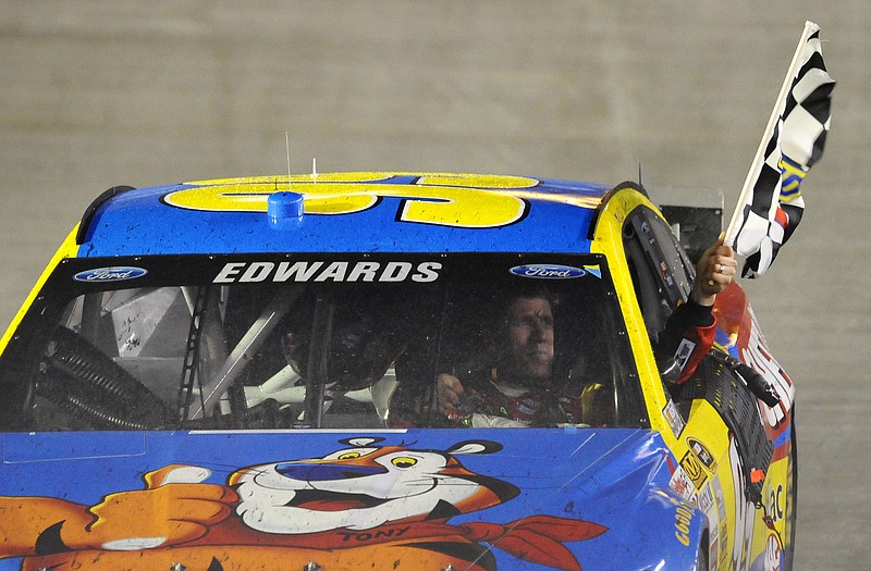 Carl Edwards takes a victory lap with the checkered flag after winning Sunday's race at Bristol Motor Speedway in Bristol, Tenn.