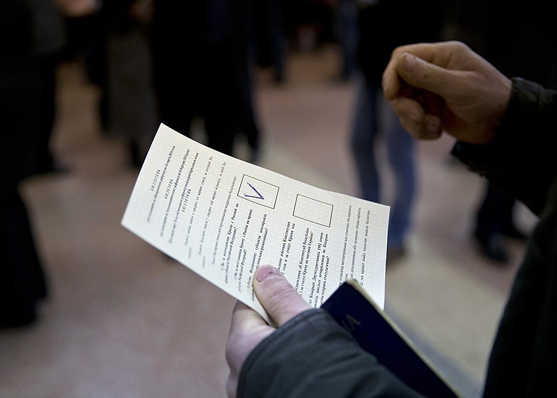 A man holds a ballot Sunday after casting a vote in favor of separation from Ukraine in the Crimean referendum in Simferopol, Ukraine. Residents of Ukraine's Crimea region are voting in a contentious referendum on whether to split off and seek annexation by Russia. 