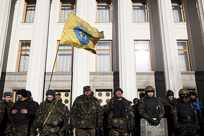 Self defense volunteers line up outside the Parliament in Kiev, Ukraine, on Monday. A referendum held in Crimea on Sunday was widely condemned by Western leaders who announced economic sanctions to punish Russia on Monday.