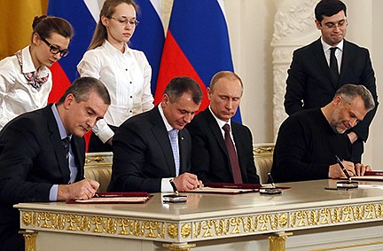 Russian President Vladimir Putin, second right, looks on as Crimean leaders, Speaker of Crimean legislature Vladimir Konstantinov, second left, Crimean Premier Sergei Aksyonov, left, and Sevastopol mayor Alexei Chalyi, right, sign a treaty for Crimea to join Russia in the Kremlin in Moscow,  Tuesday, March 18, 2014. President Vladimir Putin on Tuesday signed a treaty to incorporate Crimea into Russia, describing the move as the restoration of historic injustice and a necessary response to what he called the Western encroachment on Russias vital interests.  (AP Photo/Sergei Ilnitsky, Pool)