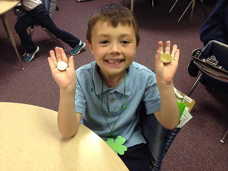 St. Andrew student Brady Dicus holding his gold coins