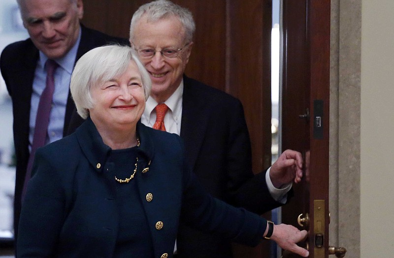 In this Monday, Feb. 3, 2014, file photo, Janet Yellen, followed by her husband, Nobel Prize winning economist George Akerlof, smiles as she walks into a room of applause by staff members before she is administered the oath of office as Federal Reserve Board chair, at the Federal Reserve in Washington. Yellen is the first woman to lead the Federal Reserve.