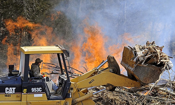 Thomas Brown of J.C. Industries delivers a load of debris to the burn pile on Wednesday afternoon as excavation and clearing efforts continue at the Frog Hollow Road rerouting project site.