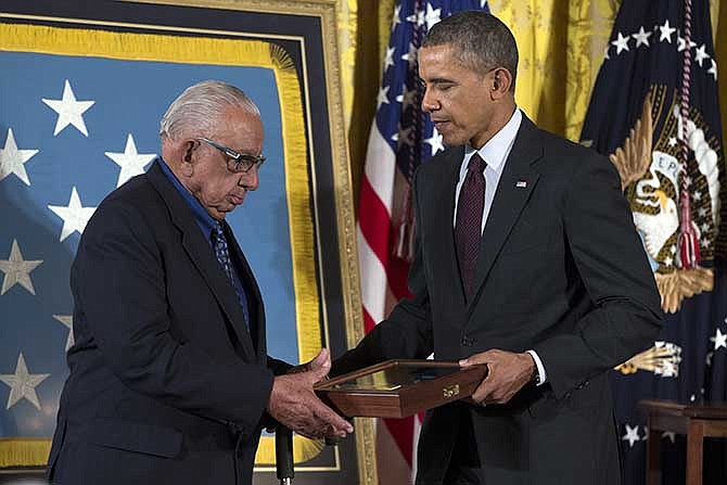 Alfonzo Lara, accepts the Medal of Honor on behalf of his brother, Pfc. Salvador J. Lara, from President Barack Obama during a ceremony in the East Room of the White House on Tuesday, March 18, 2014, in Washington. Obama awarded 24 Army veterans the Medal of Honor for conspicuous gallantry in recognition of their valor during major combat operations in World War II, the Korean War and the Vietnam War. 