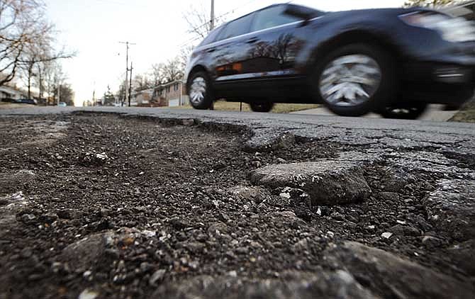 A motorist drives past a large pothole along Belair Drive near the Ker-Mac intersection on Wednesday. 