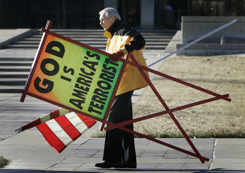 In this July 1, 2007 file phtoo, the Rev. Fred Phelps Sr. prepares to protest outside the Kansas Statehouse in Topeka, Kan. Phelps, the founder of the Kansas church known for anti-gay protests and pickets at military funerals, died Thursday. He was 84.
