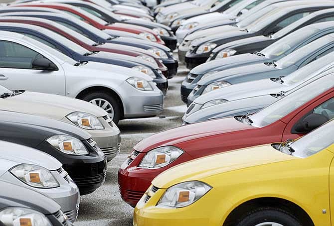 In this Friday, Dec. 12, 2008, file photo, rows of cars sit on the lot at the Lordstown, Ohio The families of three teenagers killed or injured in a 2006 Wisconsin car crash are suing General Motors, alleging that the company was negligent in designing its small cars and committed fraud by not disclosing facts about the defects. 