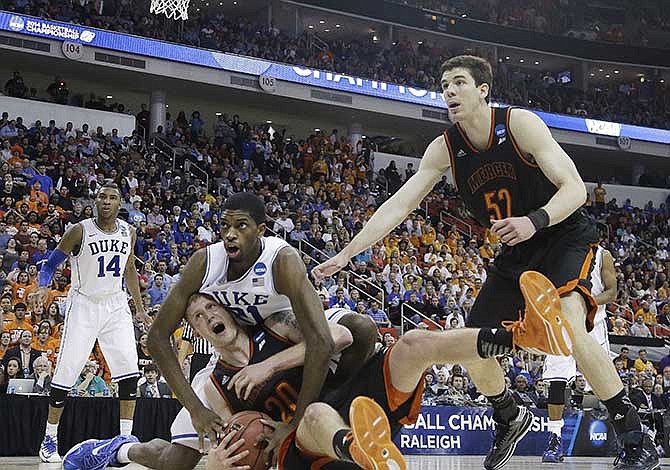 Mercer forward Jakob Gollon (20) fights for the ball with Duke forward Amile Jefferson (21) during the second half of an NCAA college basketball second-round game, Friday, March 21, 2014, in Raleigh, N.C. Mercer won 78-71. 