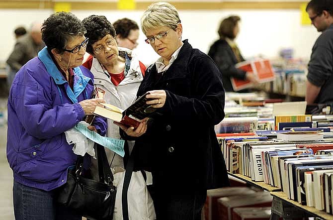 Tonya Willig of Jefferson City, right, looks over a book with her mother Evey Turner, left, and aunt Tootsie Durrill, both of Sedalia, during the annual Missouri River Regional Library and Adult Basic Literacy Education  used book sale at the St. Martins Knights of Columbus Hall on Wednesday, March 12, 2014.