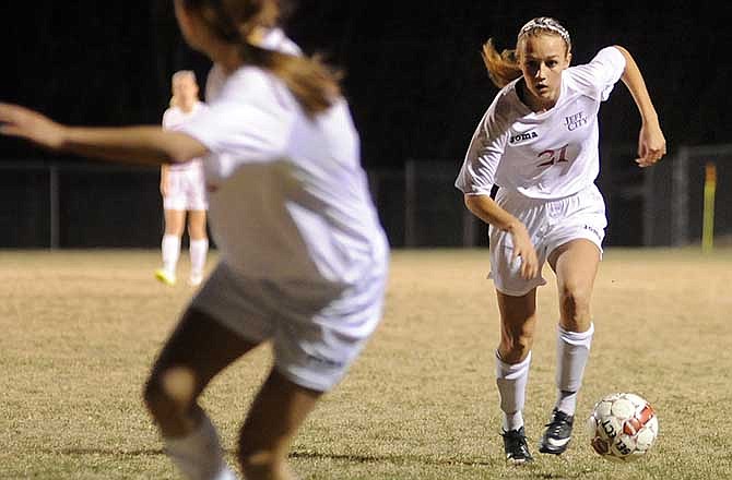 Sarah Luebbert of Jefferson City pushes the ball up the field as Natalie Vance turns to make a run to the corner during Friday night's action against Troy at the 179 Soccer Park.