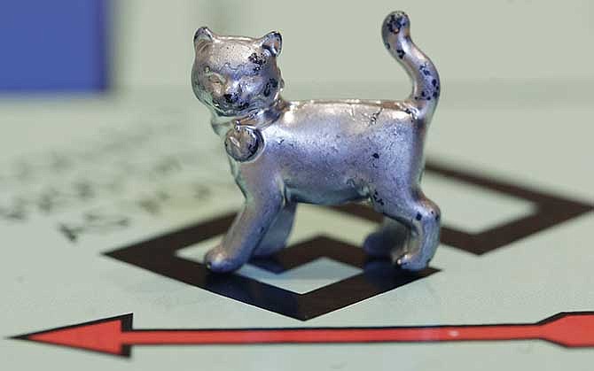 In this Tuesday, Feb. 5, 2013, file photo, the Monopoly token shaped as a cat rests on the game board at Hasbro Inc. headquarters, in Pawtucket, R.I.